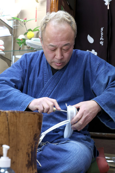 鼻緒を取り付ける店主の桜井さん（Ｃ）日刊ゲンダイ