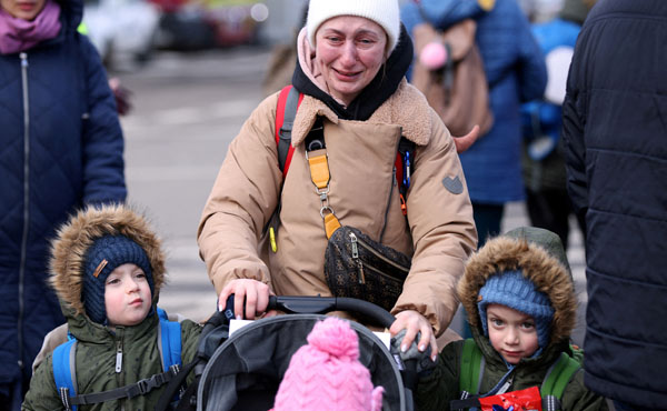 ロシアのウクライナ侵攻から逃れ、子供の隣で泣いている女性（ルーマニア・シレト）／（Ｃ）ロイター