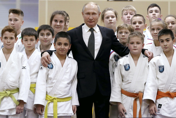 少年時代に稽古した柔道場で子どもたちと記念撮影に応じるプーチン大統領は有段者として知られているが…（Ｃ）タス=共同