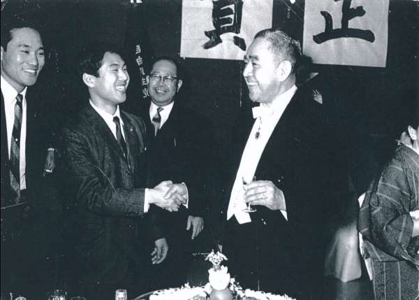 佐藤栄作首相と握手しながら談笑する中原氏。自民党本部の正月事始めで（提供写真）