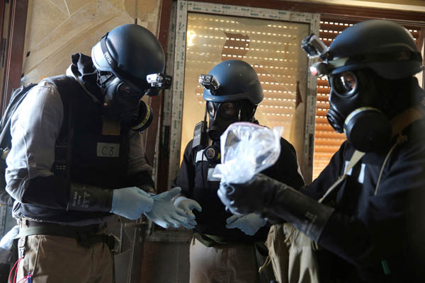 2013年、シリア内戦。化学兵器攻撃の嫌疑が掛かっている地域で、ガスマスクをして、現場の1つからサンプルが入っているビニール袋を持つ国連の化学兵器専門家（Ｃ）ロイター