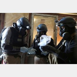 2013年、シリア内戦。化学兵器攻撃の嫌疑が掛かっている地域で、ガスマスクをして、現場の1つからサンプルが入っているビニール袋を持つ国連の化学兵器専門家（Ｃ）ロイター
