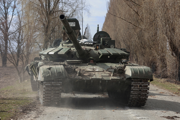 交戦で捕らえたロシア軍の戦車Ｔ－72を運転し移動させるウクライナ兵士（首都キーウ周辺、ルキヤノフカ村）／（Ｃ）ロイター