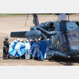 24日、自衛隊ヘリから救助された人を搬送する救急隊員ら（Ｃ）共同通信社