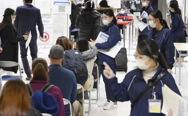 海外から成田空港に到着した乗客の対応をする検疫担当者（2020年12月）／（Ｃ）共同通信社