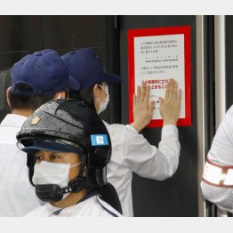 神戸山口組系池田組の事務所ドアに「特定抗争指定暴力団」に指定したことを示す標章を張る県警（Ｃ）共同通信社