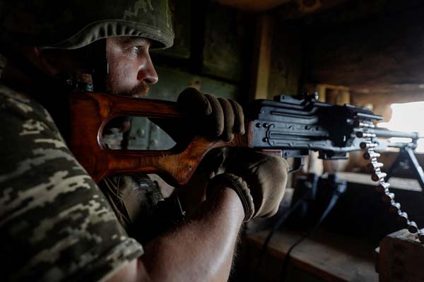 ウクライナ東部ドネツク地域の最前線、機関銃を構え、自分の定位置につくウクライナ軍兵士（Ｃ）ロイター