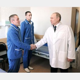 負傷兵とぎこちない握手（ロシアのプーチン大統領）　（Ｃ）ロイター／Sputnik
