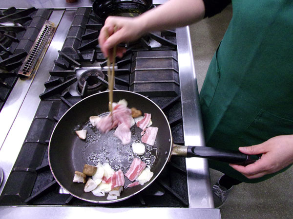 豚肉、スライスしたニンニクとシイタケを一緒に炒める（Ｃ）日刊ゲンダイ