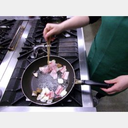 豚肉、スライスしたニンニクとシイタケを一緒に炒める（Ｃ）日刊ゲンダイ