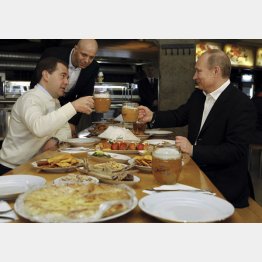 3期目就任直前、ビアホールで乾杯するロシアのプーチン大統領（メドベージェフ前大統領＝左、と）／（Ｃ）ロイター