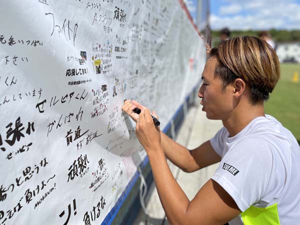 横断幕にサインを入れるFC町田ゼルビアの選手（提供写真）