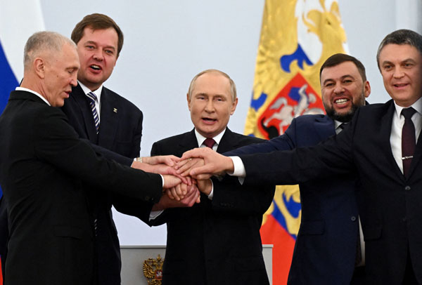 4州併合署名後、ウクライナ東・南部の親ロ派地域代表らと握手するロシアのプーチン大統領（中央）　（Ｃ）ロイター／Sputnik