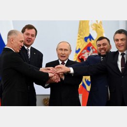 4州併合署名後、ウクライナ東・南部の親ロ派地域代表らと握手するロシアのプーチン大統領（中央）　（Ｃ）ロイター／Sputnik