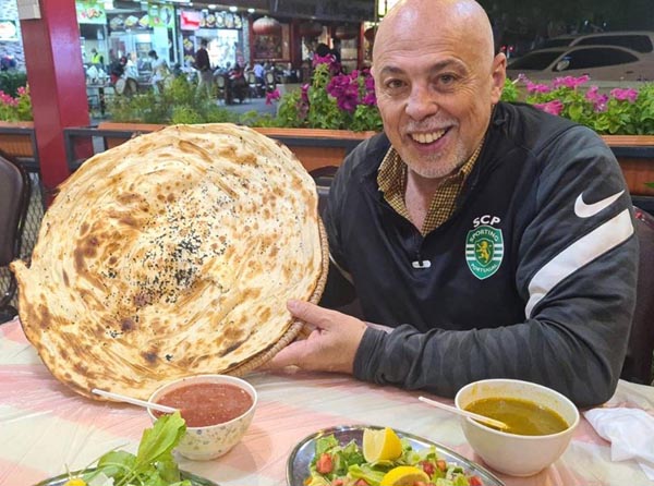ドーハ市内のレストランでカタール料理のホブスを手にする筆者（本人提供）