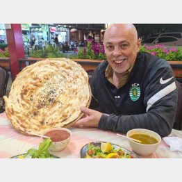 ドーハ市内のレストランでカタール料理のホブスを手にする筆者（本人提供）