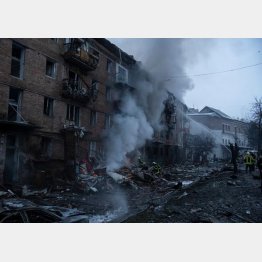 ロシアの攻撃を受けた居住建物の消火活動をする消防隊員ら（23日、首都キーウ）／（Ｃ）ロイター