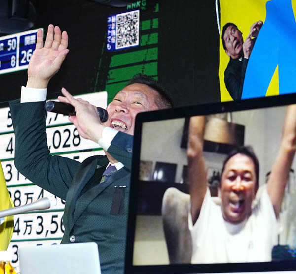 比例代表で当選が決まったガーシー氏（画面）と喜ぶNHK党の立花党首（Ｃ）共同通信社