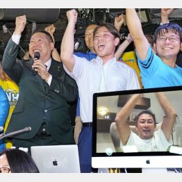 2022年7月の参院選比例代表で当選が決まったガーシー氏（画面）と喜ぶNHK党の立花党首（左）ら（Ｃ）共同通信社