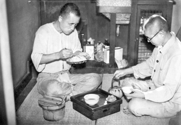 釈放待つ政治犯。東京・府中刑務所の予防拘禁所で自炊の朝食を食べる日本共産党幹部の志賀義雄（左）と三田村四郎。10日に釈放された。＝1945年10月7日（Ｃ）共同通信社