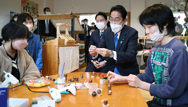 岡山県奈義町で「なぎチャイルドホーム」を視察し、子どもと工作を楽しむ岸田首相（右2、＝代表撮影）