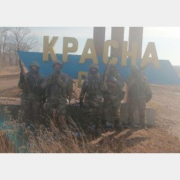 ウクライナ東部ドネツク州バフムに近い村の入り口で記念撮影をする「ワグネル」の戦闘員ら（ロシア民間軍事会社「ワグネル」創始者・プリゴジン氏提供）／（C)ロイター