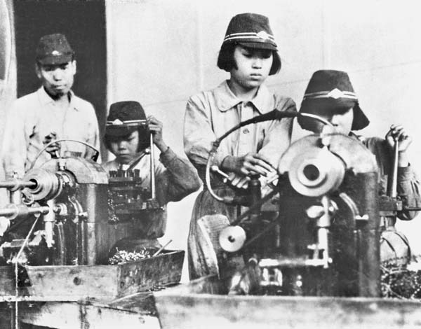 1944年6月8日、戦争の拡大で労働力が極端に不足し始めた太平洋戦争末期、「女子挺身隊」の若い女性が勤労奉仕で、B29による爆撃の標的とされる航空機製造の軍需工場などへも駆り出された。旋盤機械を操作する表情にはかなりの幼さが残る（Ｃ）共同通信社