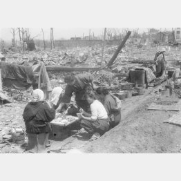 大空襲で一面の焼け野原となった跡地で生活する人たち＝1945年5月、都内（Ｃ）共同通信社