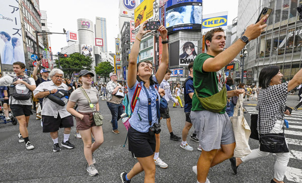 東京・渋谷のスクランブル交差点を横断する米国からの観光客（Ｃ）共同通信社
