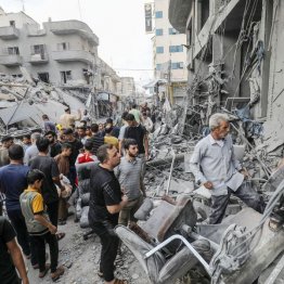 パレスチナ自治区ガザで、イスラエル軍の空爆を受けた建物を調べる人たち＝10日（Ｃ）ゲッティ＝共同