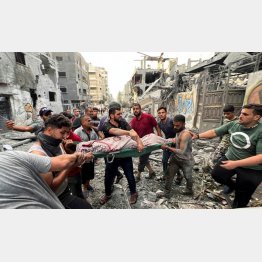 空爆で倒壊した建物から負傷者を救出するパレスチナ自治区のガザ市民（Ｃ）ロイター