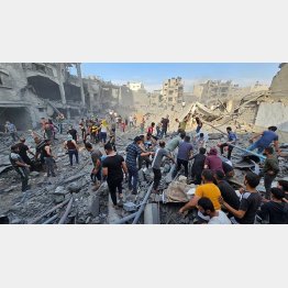 イスラエルの空爆を受けたガザ難民キャンプ。崩壊した建物のなか、生存者を探すパレスチナ人たち（Ｃ）ロイター