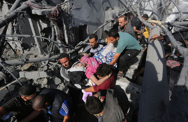 続くイスラエルの空爆で、倒壊した居住建物から負傷者を救出するパレスチナ民（Ｃ）ロイター