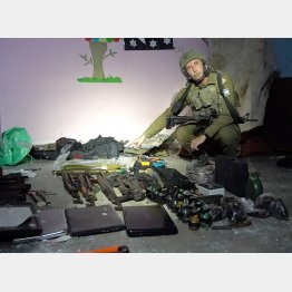 病院地下で発見した武器をみせるイスラエル軍少将。ハマスは医療施設や一般人を「人間の盾」にして司令部や武器を隠しているとイスラエル軍は主張（Ｃ）ロイター／イスラエル国防軍