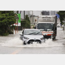大雨の影響で冠水した道路を走る車（2023年7月福岡県久留米市）／（Ｃ）共同通信社