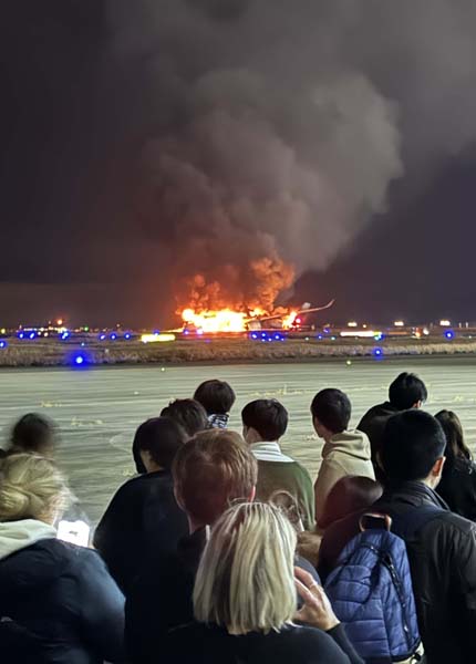 羽田空港の滑走路で炎上する日航機から離れ、待機する516便の乗客たち（Ｃ）日刊ゲンダイ／中西直樹