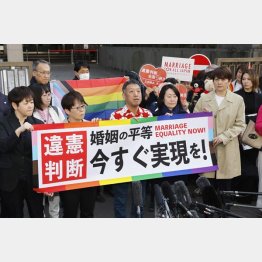 3月14日、同性婚を巡る東京第２次訴訟の判決後、東京地裁前でメッセージを掲げ取材に応じる原告ら（Ｃ）共同通信社