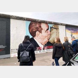 有名な壁アート「兄弟のキス」（左から、ソ連のブレジネフ書記長と東ドイツのホーネッカー議長）／（Ｃ）日刊ゲンダイ