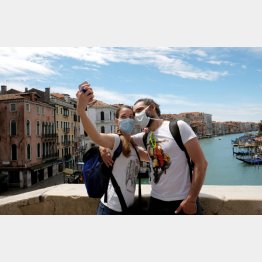 ヴェネチアの観光地で写真を撮るマスク姿の観光客（Ｃ）ロイター