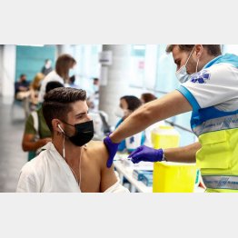 新型コロナウイルスワクチンの接種を受ける若い男性（スペイン）／（Ｃ）ロイター