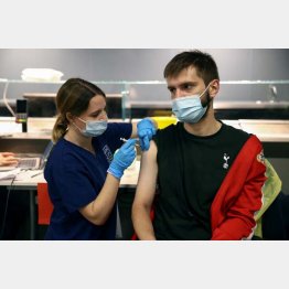 ファイザー製ワクチンを接種される若者（ロンドン＝トッテナム・ホットスパースタジアム）／（Ｃ）ロイター