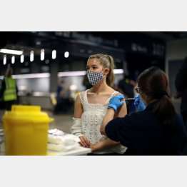 集団ワクチン接種センターでファイザー製ワクチンを接種される若者（ロンドン＝トッテナム・ホットスパースタジアム）／（Ｃ）ロイター