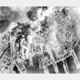 米軍21爆撃軍団の戦略爆撃機B29の爆撃で黒煙を上げる神戸港(1945=昭和20=年6月、米陸軍航空隊撮影)(C)ACME/共同通信社