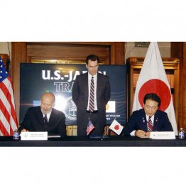 日米関税合意に関する文書に署名する赤沢経済再生相(右)とラトニック米商務長官(C)共同通信社