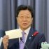 雅子さんからの手紙を掲げる加藤財務相（撮影）相澤冬樹