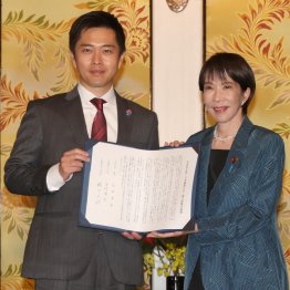 連立政権合意書を手に、写真撮影に応じる日本維新の会の吉村代表(左)と自民党の高市総裁(C)日刊ゲンダイ