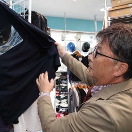 商品を手にする臂社長（Ｃ）日刊ゲンダイ