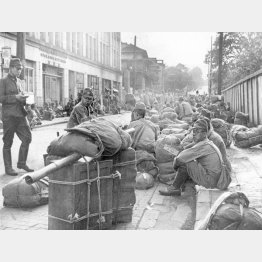 東京の路上で、将校から動員解除命令を聞かされる日本軍の復員兵士たち（1945＝昭和20＝年9月、米海軍撮影〈ＡＣＭＥ〉）／（Ｃ）共同通信社