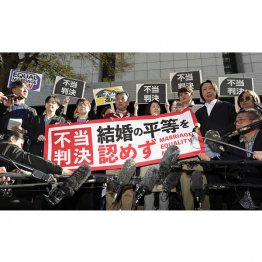 同性カップルら8人が国に損害賠償を求めた東京第2次訴訟の控訴審判決を受け「不当判決」などと書かれた紙を掲げる原告ら（Ｃ）共同通信社