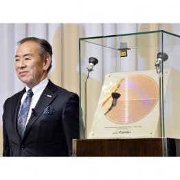 回路を形成したウエハーと呼ばれる基板（右）を横に、会見するラピダスの小池淳義社長（Ｃ）共同通信社
